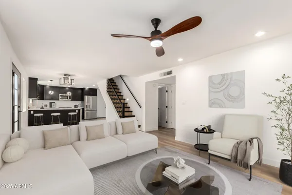 a living room with furniture and a ceiling fan
