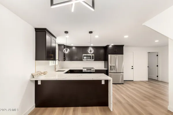 a kitchen with stainless steel appliances a sink and a refrigerator