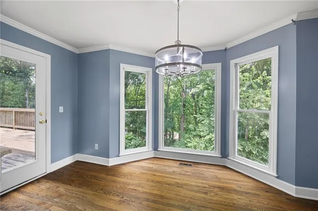 a view of a livingroom with windows wooden floor and a chandelier