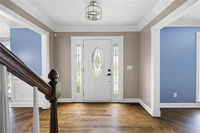 a view of a hallway with wooden floor and entryway
