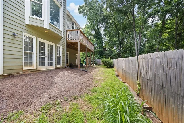 a view of a backyard with a trees and wooden fence