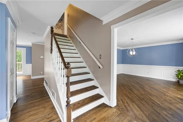 a view of a hallway with wooden floor and entryway
