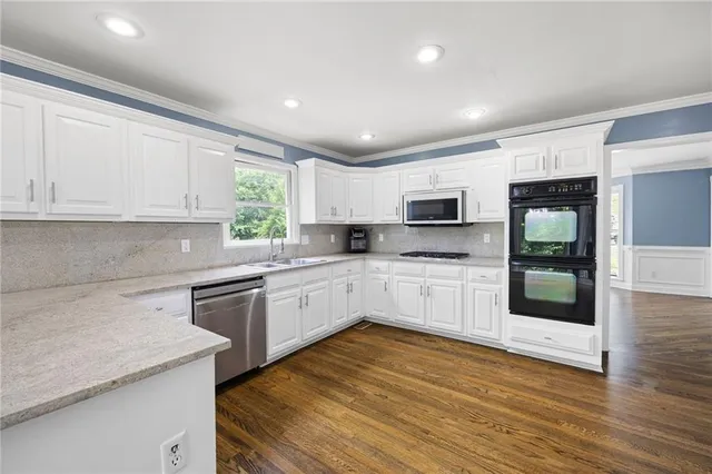 a kitchen with granite countertop a stove top oven and cabinets