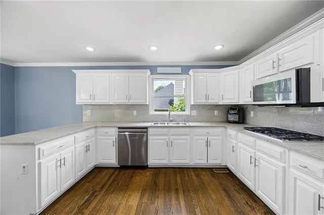 a kitchen with granite countertop white cabinets and white appliances