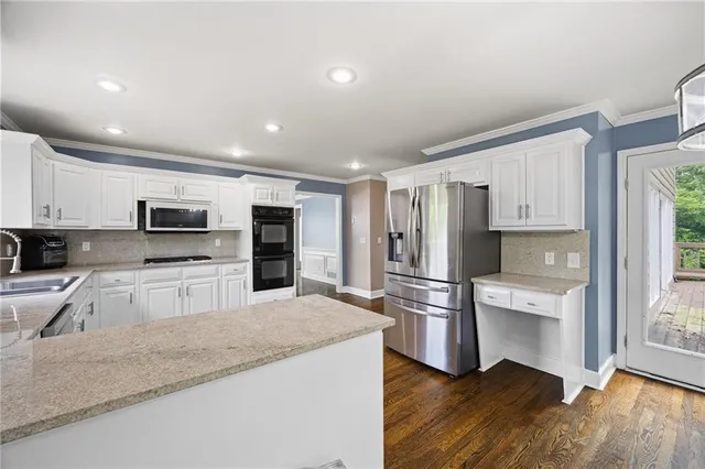 a kitchen with stainless steel appliances granite countertop a refrigerator and a stove top oven