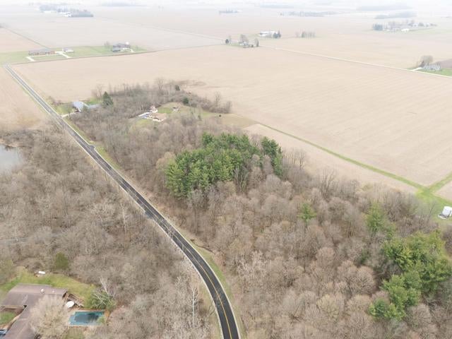 --- Childrens Home Road Sidney, OH 45365 - Photo 6 of 10 This expansive aerial view showcases a winding road through verdant woodlands and open fields.