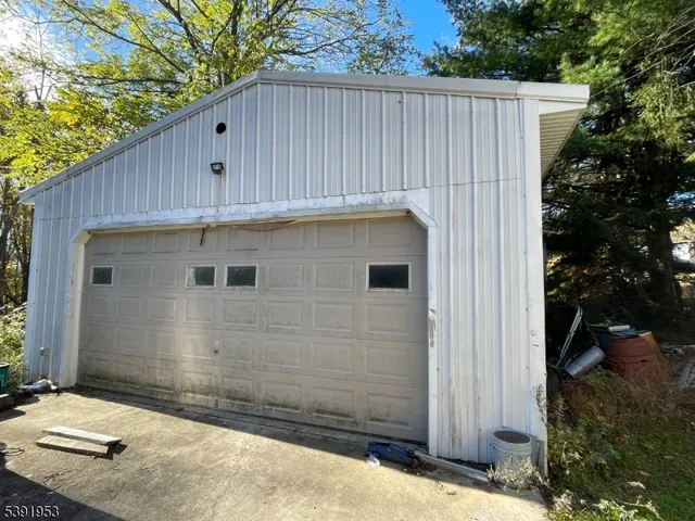 a backyard of a house with a tree and wooden fence