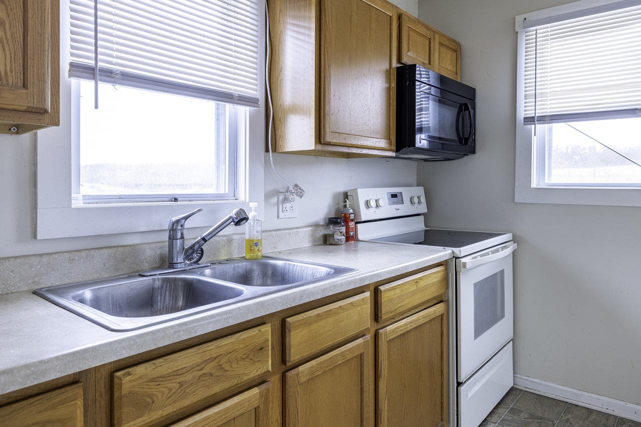 8120 Winestore Road Timberville, VA 22853 - Photo 5 of 35 a kitchen with stainless steel appliances granite countertop a sink a microwave cabinets and a window