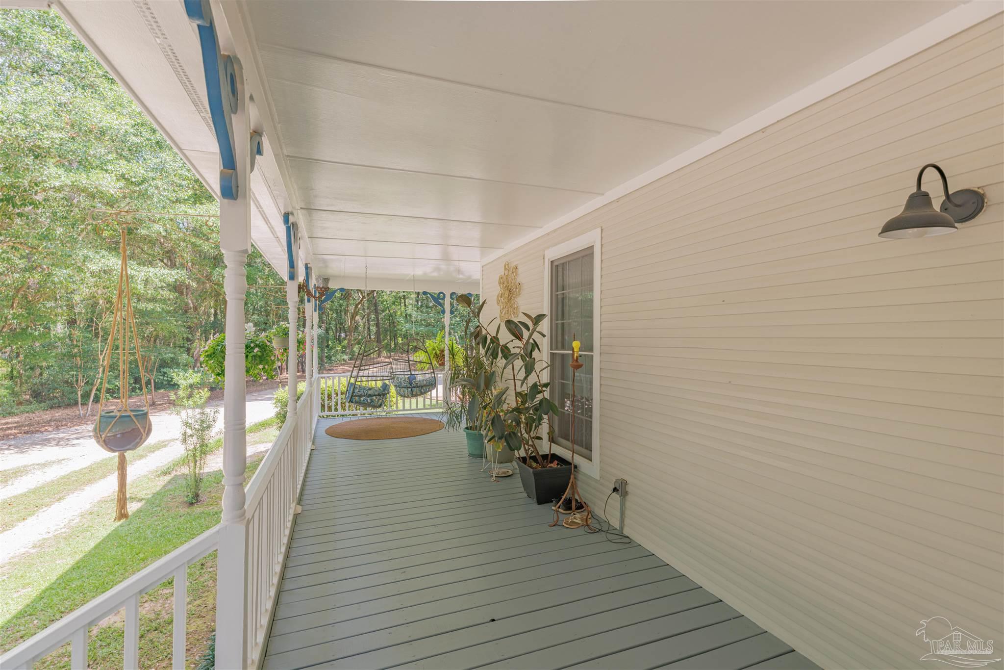 5049 Guernsey Road Pace, FL 32571 - Photo 11 of 61 a view of a porch with wooden floor and outdoor space