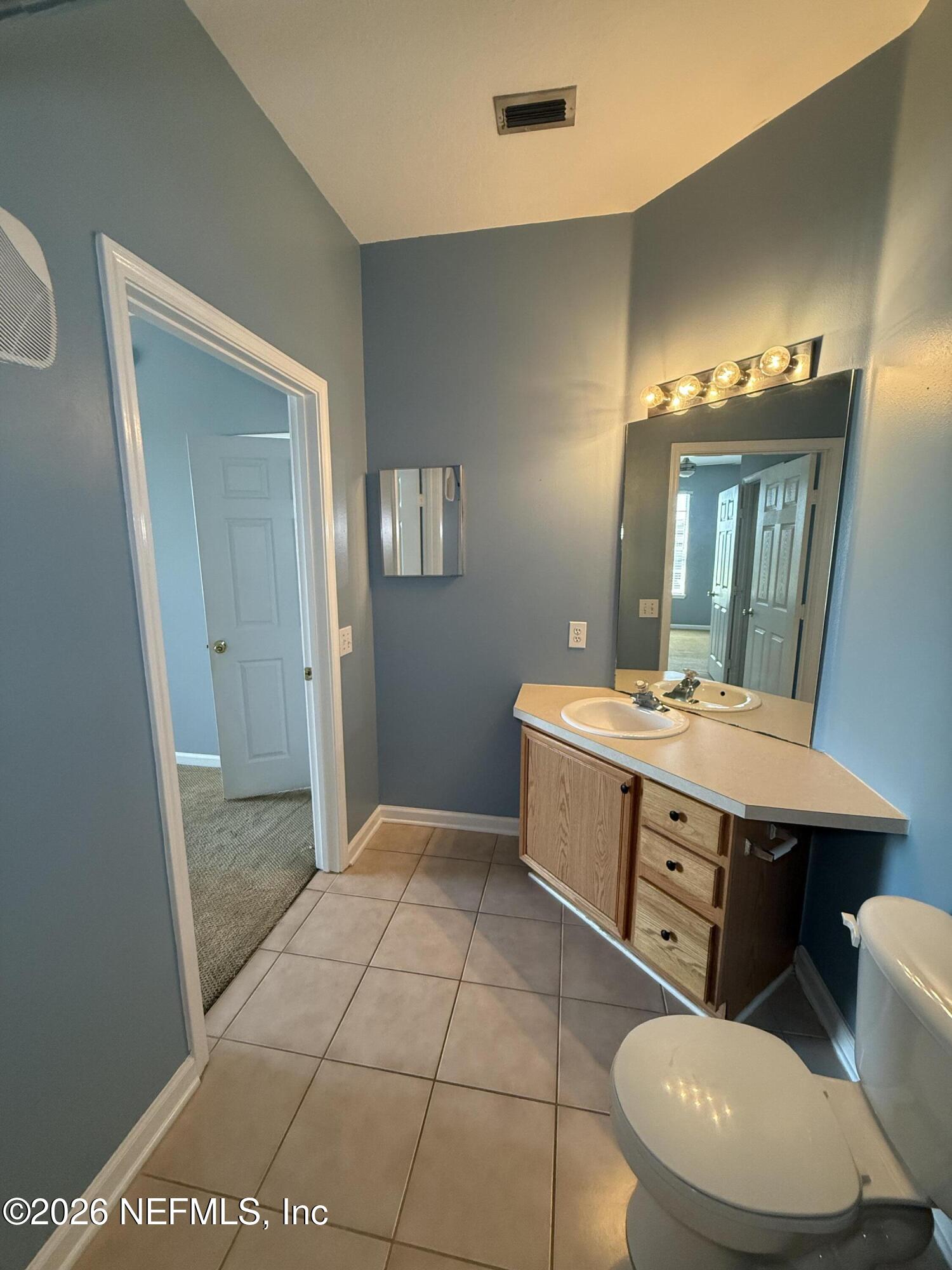 7990 Baymeadows Road, Unit 829 Jacksonville, FL 32256 - Photo 23 of 34 a spacious bathroom with a granite countertop sink a toilet a mirror and vanity