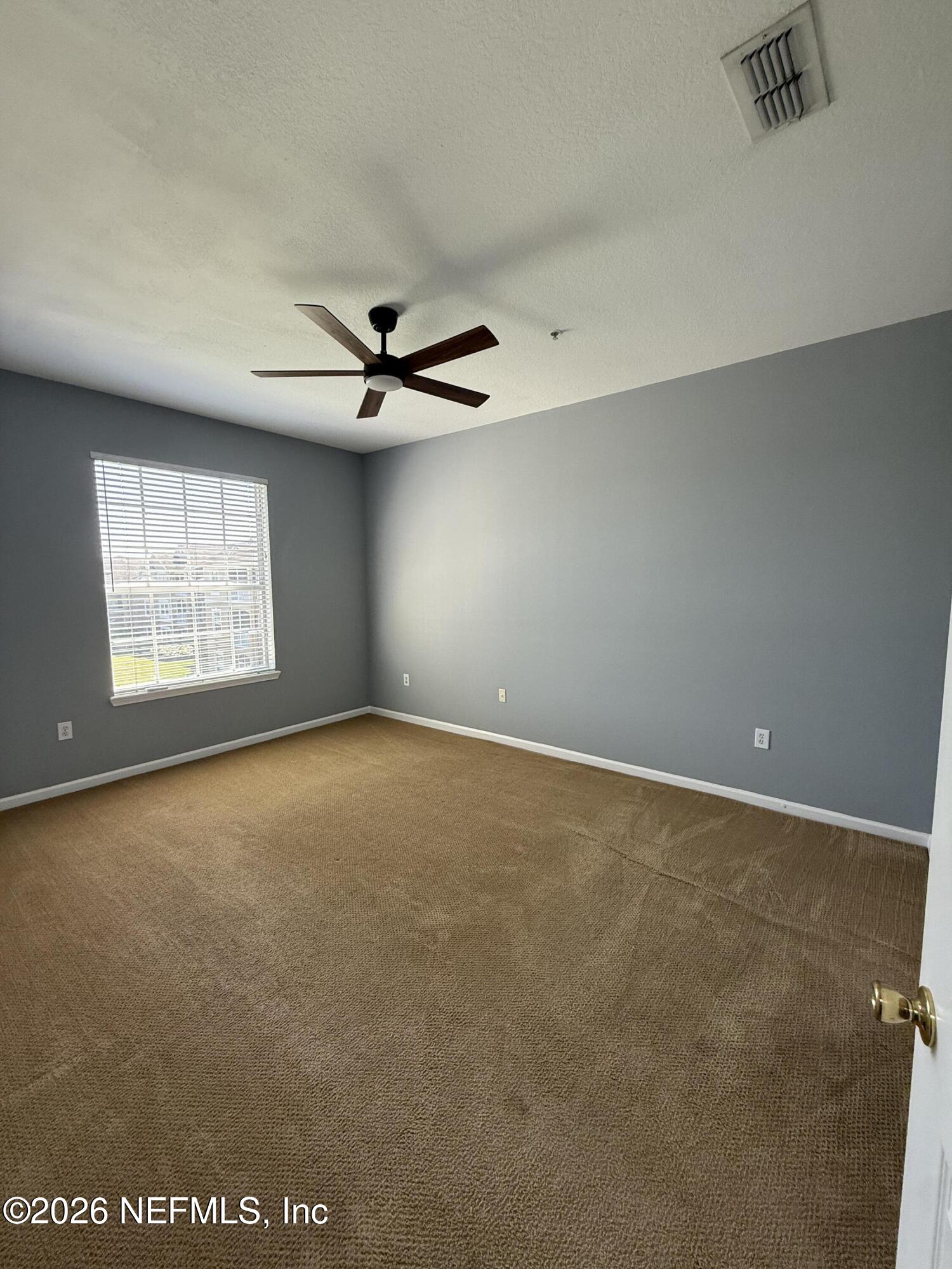 7990 Baymeadows Road, Unit 829 Jacksonville, FL 32256 - Photo 24 of 34 an empty room with windows and ceiling fan view