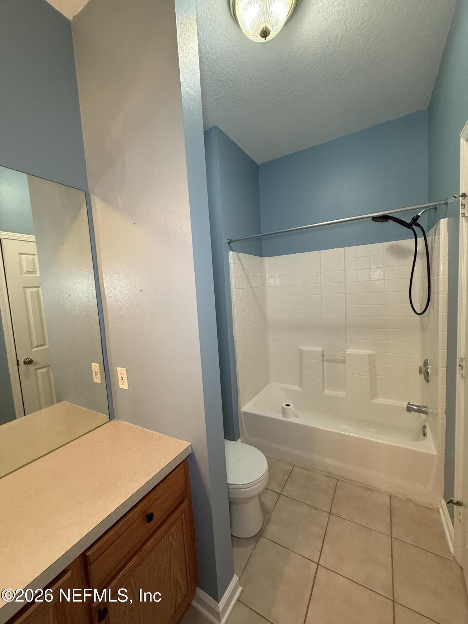 7990 Baymeadows Road, Unit 829 Jacksonville, FL 32256 - Photo 29 of 34 a bathroom with a granite countertop sink a toilet and shower