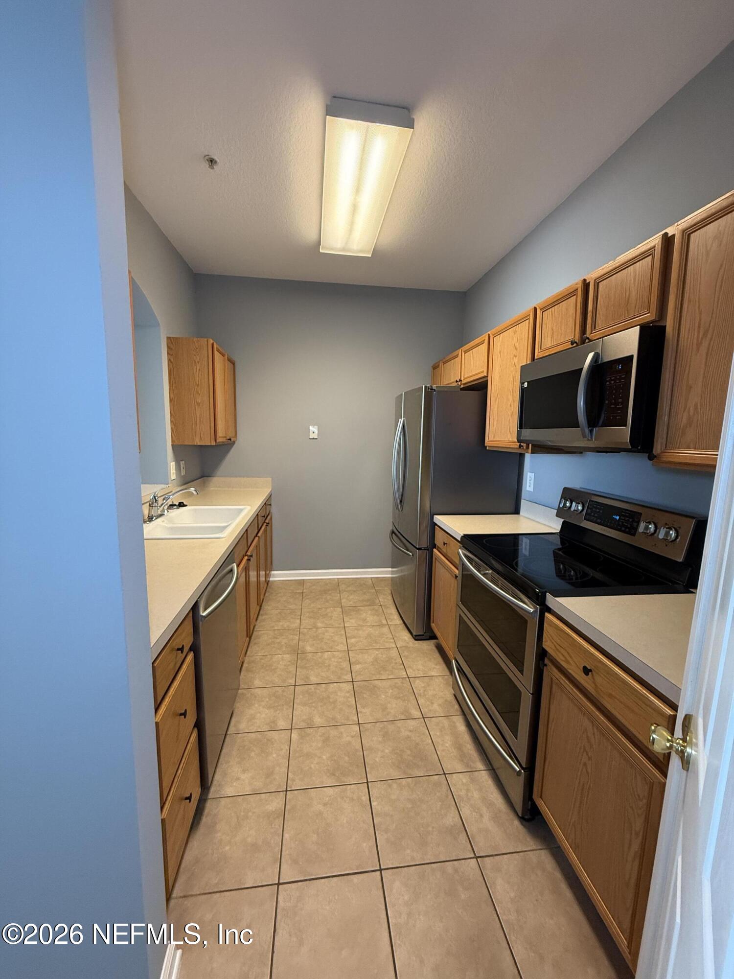 7990 Baymeadows Road, Unit 829 Jacksonville, FL 32256 - Photo 6 of 34 a kitchen with stainless steel appliances a stove microwave and sink