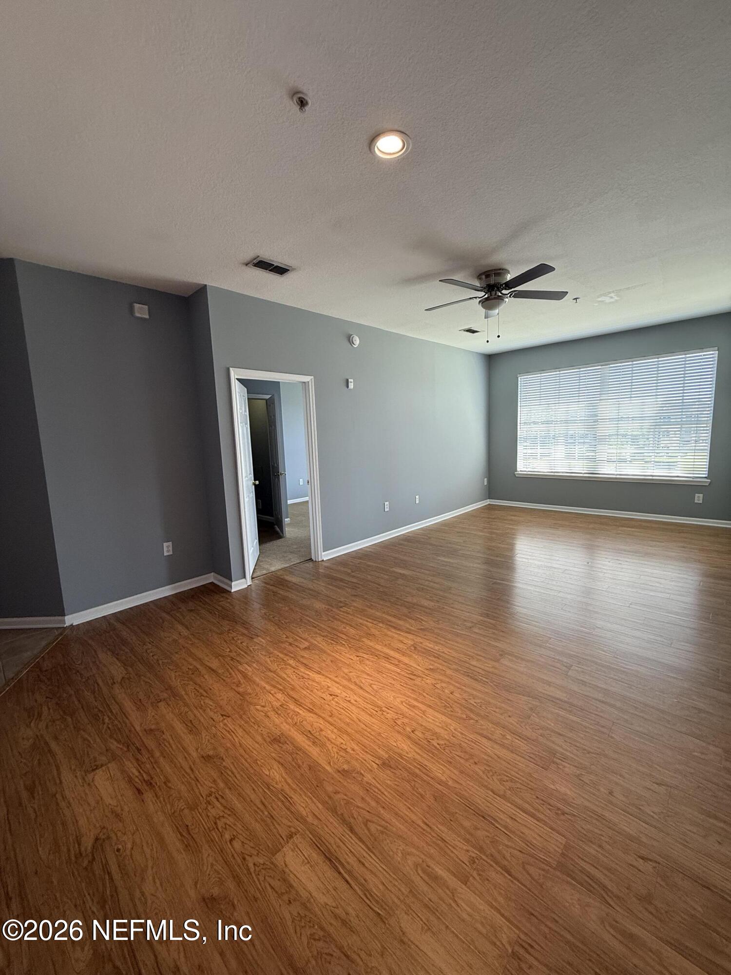 7990 Baymeadows Road, Unit 829 Jacksonville, FL 32256 - Photo 10 of 34 a view of an empty room with a window and wooden floor