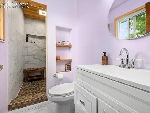 a bathroom with a sink a toilet and shower