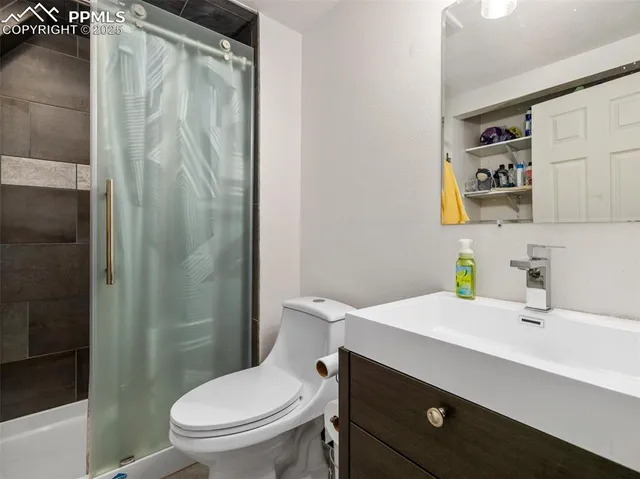 a bathroom with a sink a toilet and shower