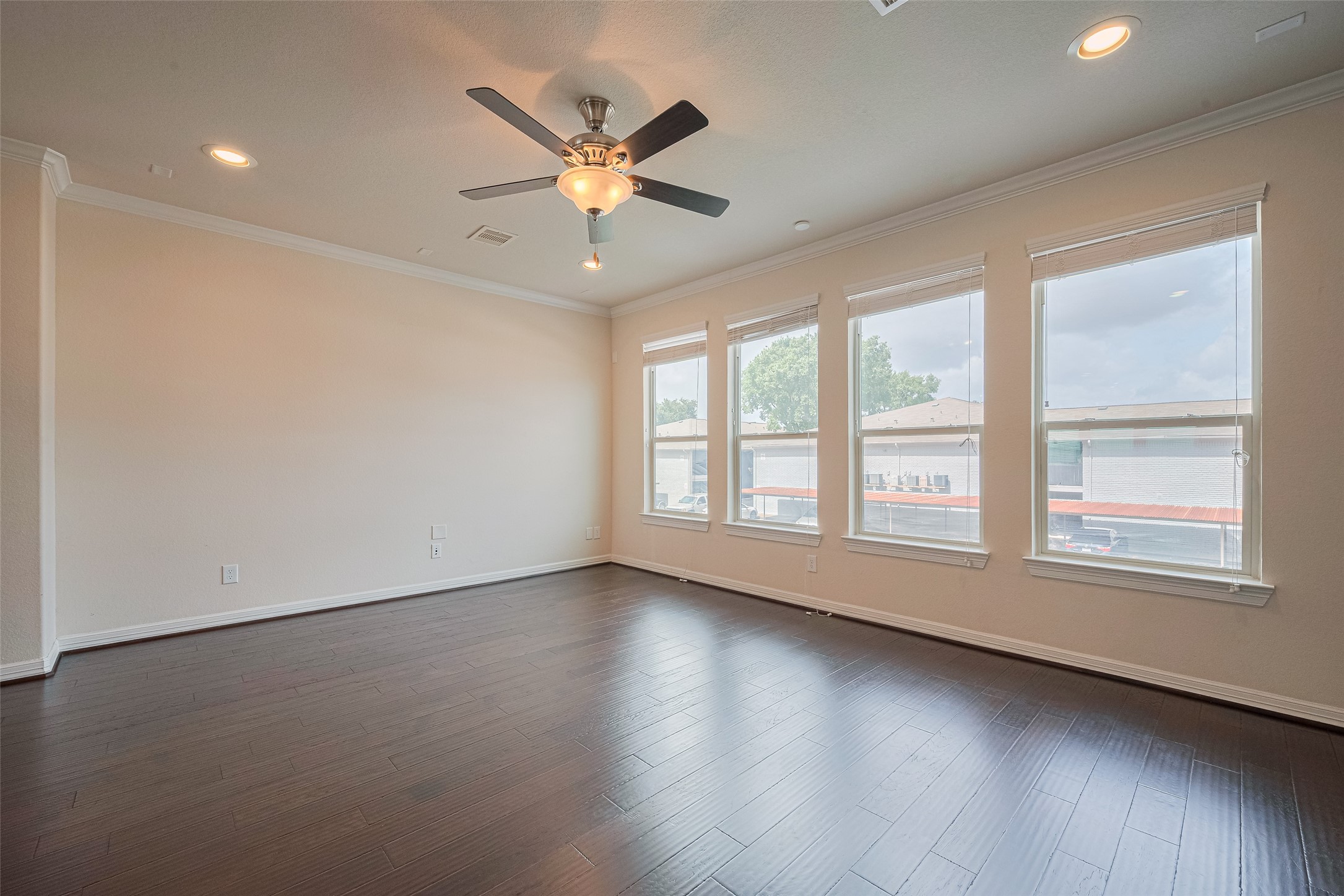 10004 Spring Shadows Park Circle Houston, TX 77080 - Photo 12 of 50 an empty room with wooden floor fan and windows