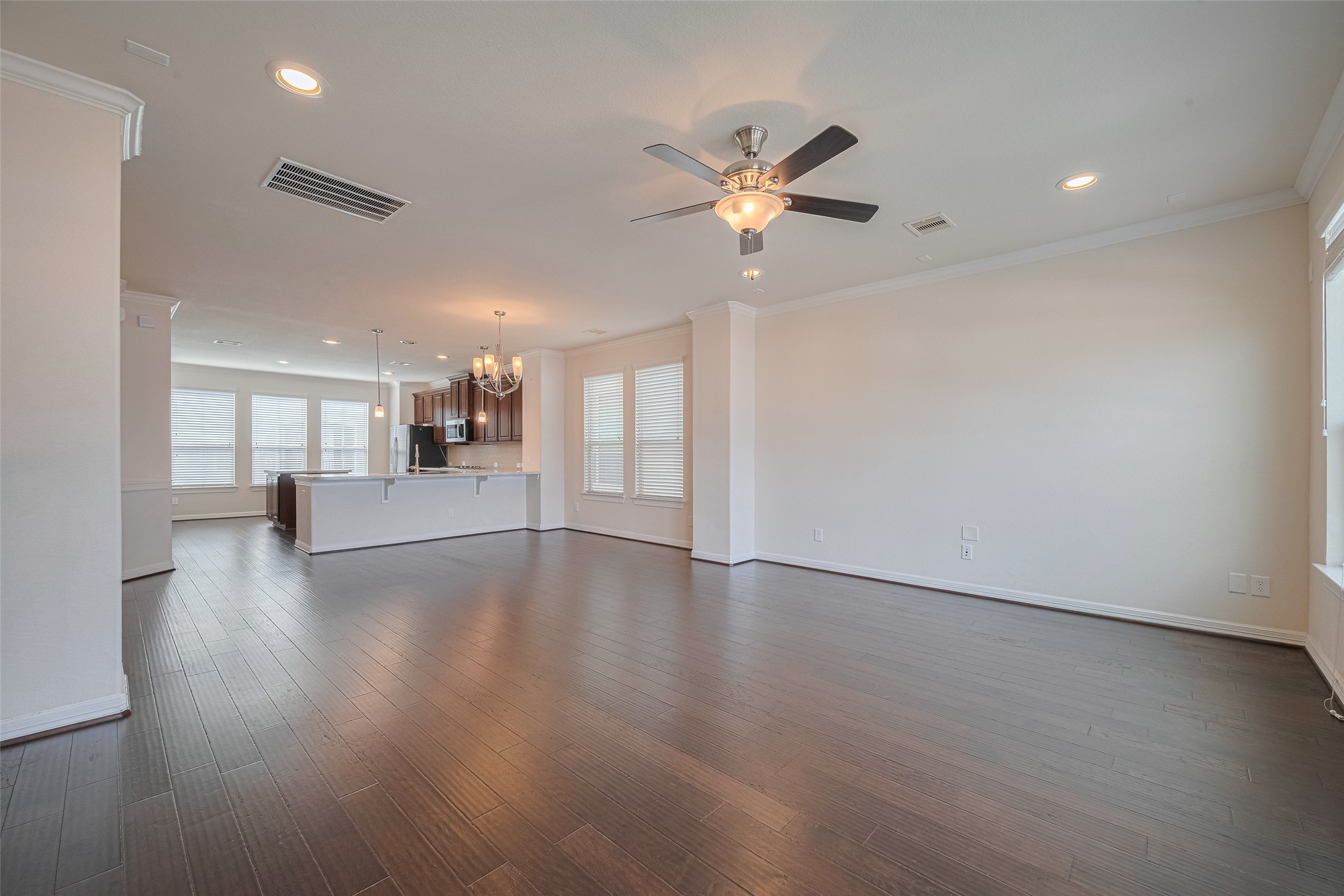 10004 Spring Shadows Park Circle Houston, TX 77080 - Photo 13 of 50 a view of an empty room with wooden floor and a ceiling fan