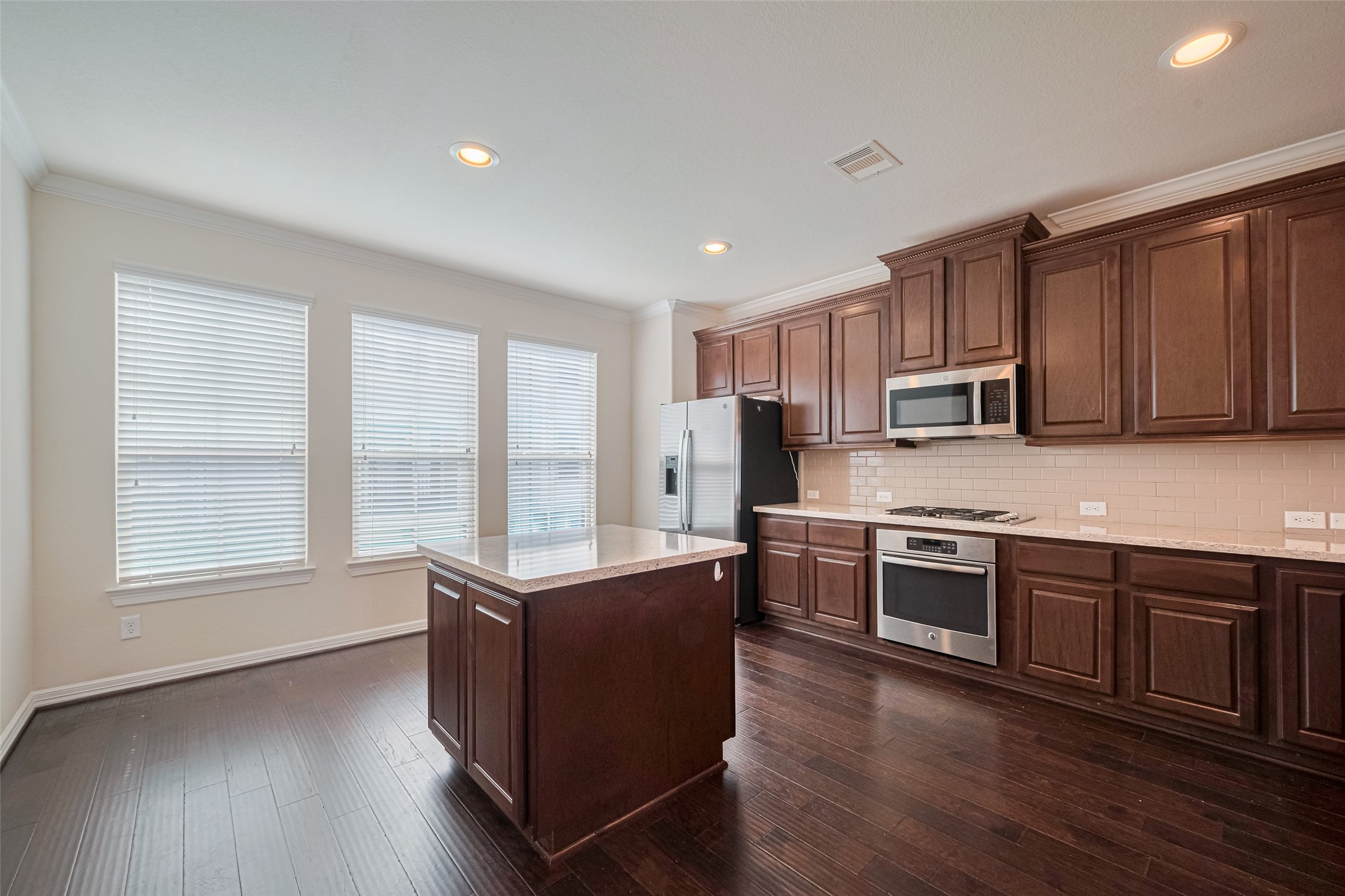 10004 Spring Shadows Park Circle Houston, TX 77080 - Photo 16 of 50 a kitchen with stainless steel appliances granite countertop wooden cabinets a stove a sink and dishwasher with wooden floor