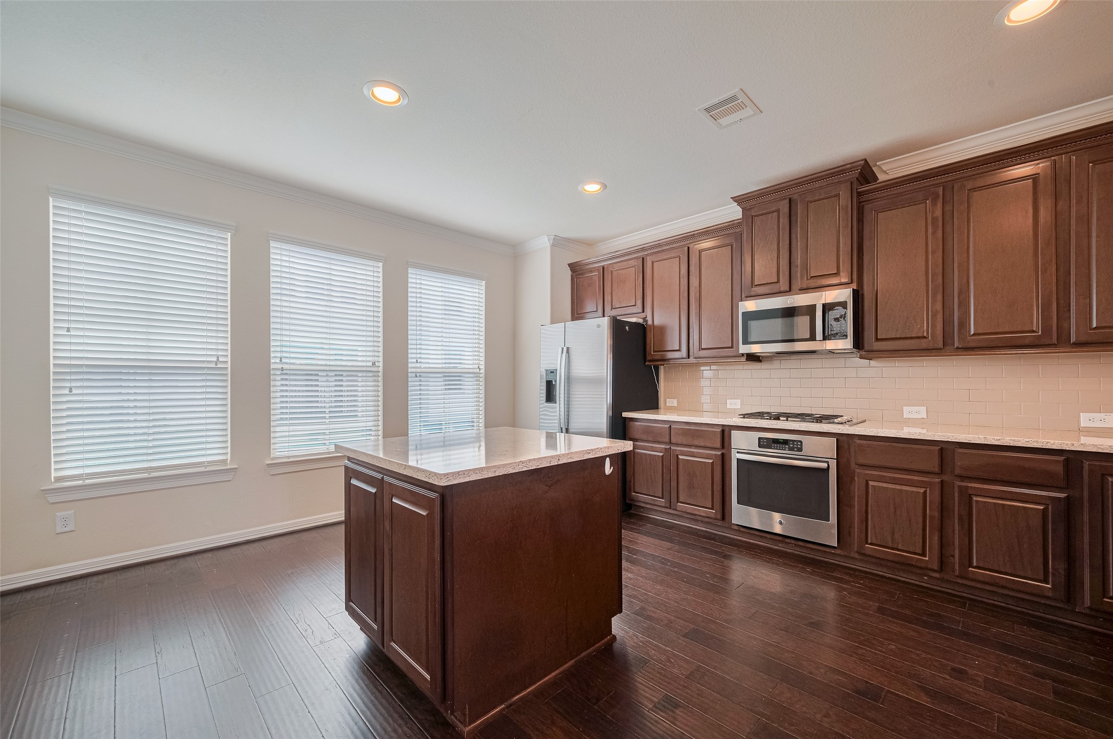 10004 Spring Shadows Park Circle Houston, TX 77080 - Photo 19 of 50 a kitchen with stainless steel appliances granite countertop wooden cabinets a stove a sink and a wooden floors