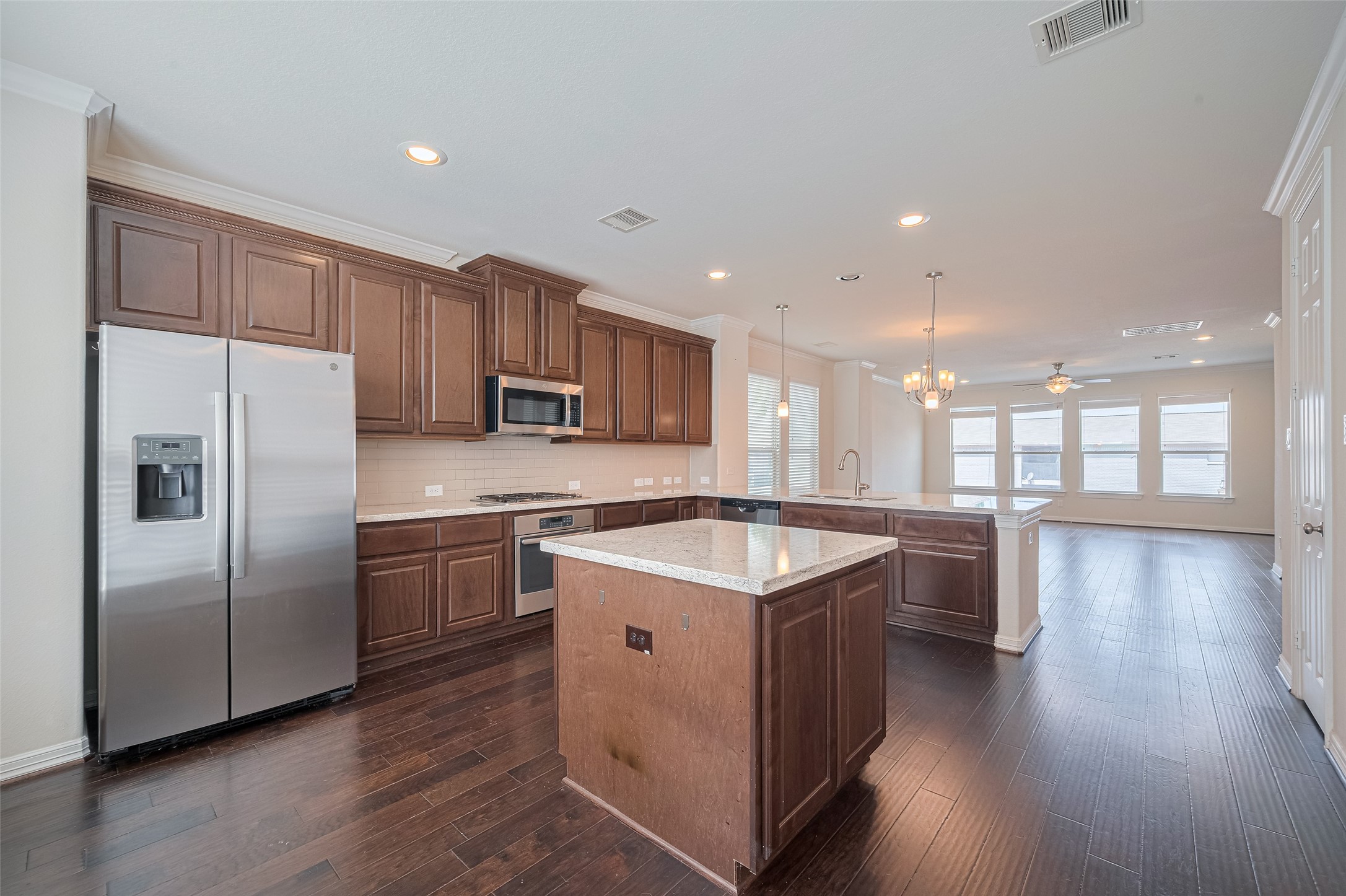 10004 Spring Shadows Park Circle Houston, TX 77080 - Photo 29 of 50 a kitchen with stainless steel appliances granite countertop a refrigerator a sink dishwasher a stove and white countertops with wooden floor