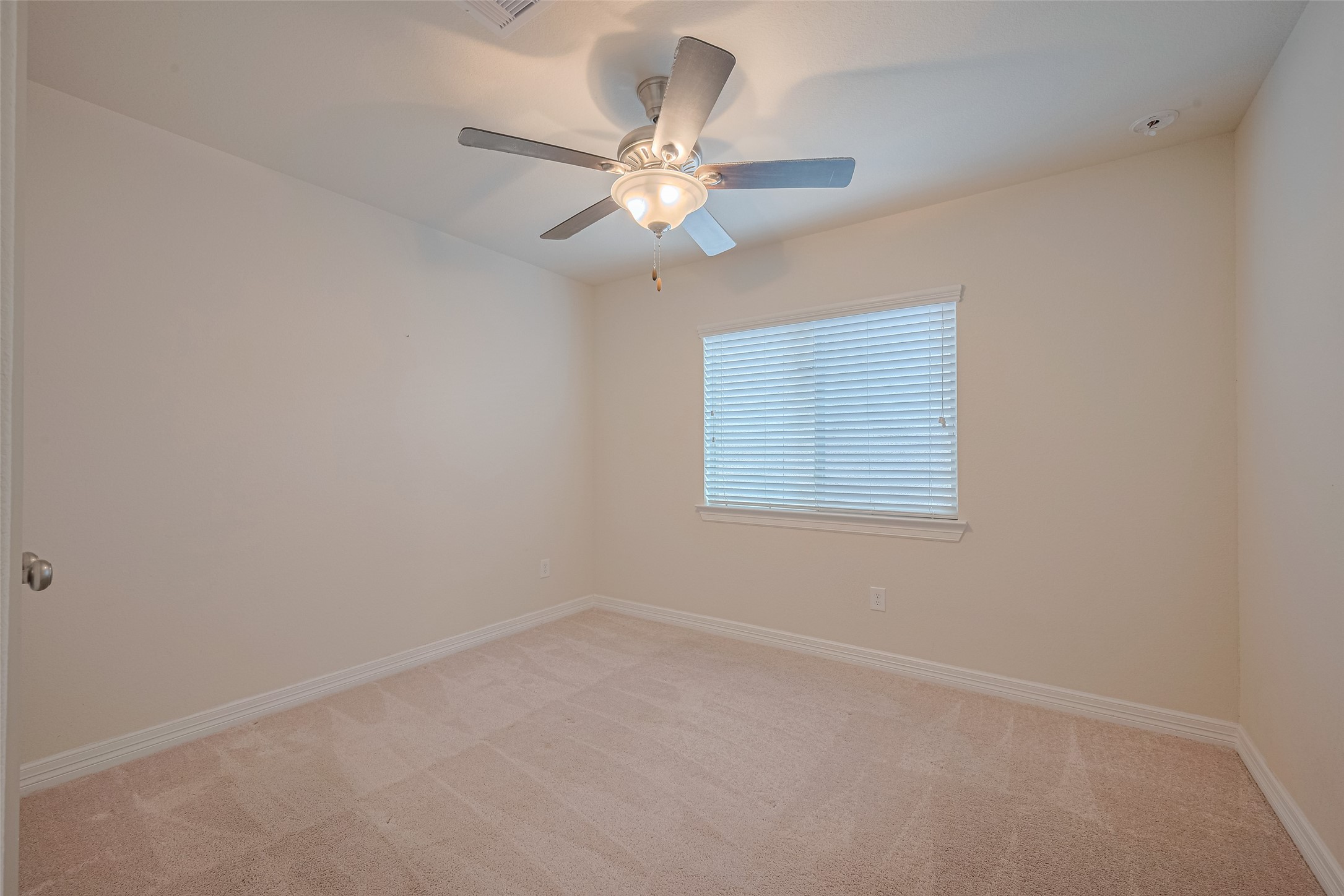10004 Spring Shadows Park Circle Houston, TX 77080 - Photo 30 of 50 an empty room with a window and a fan