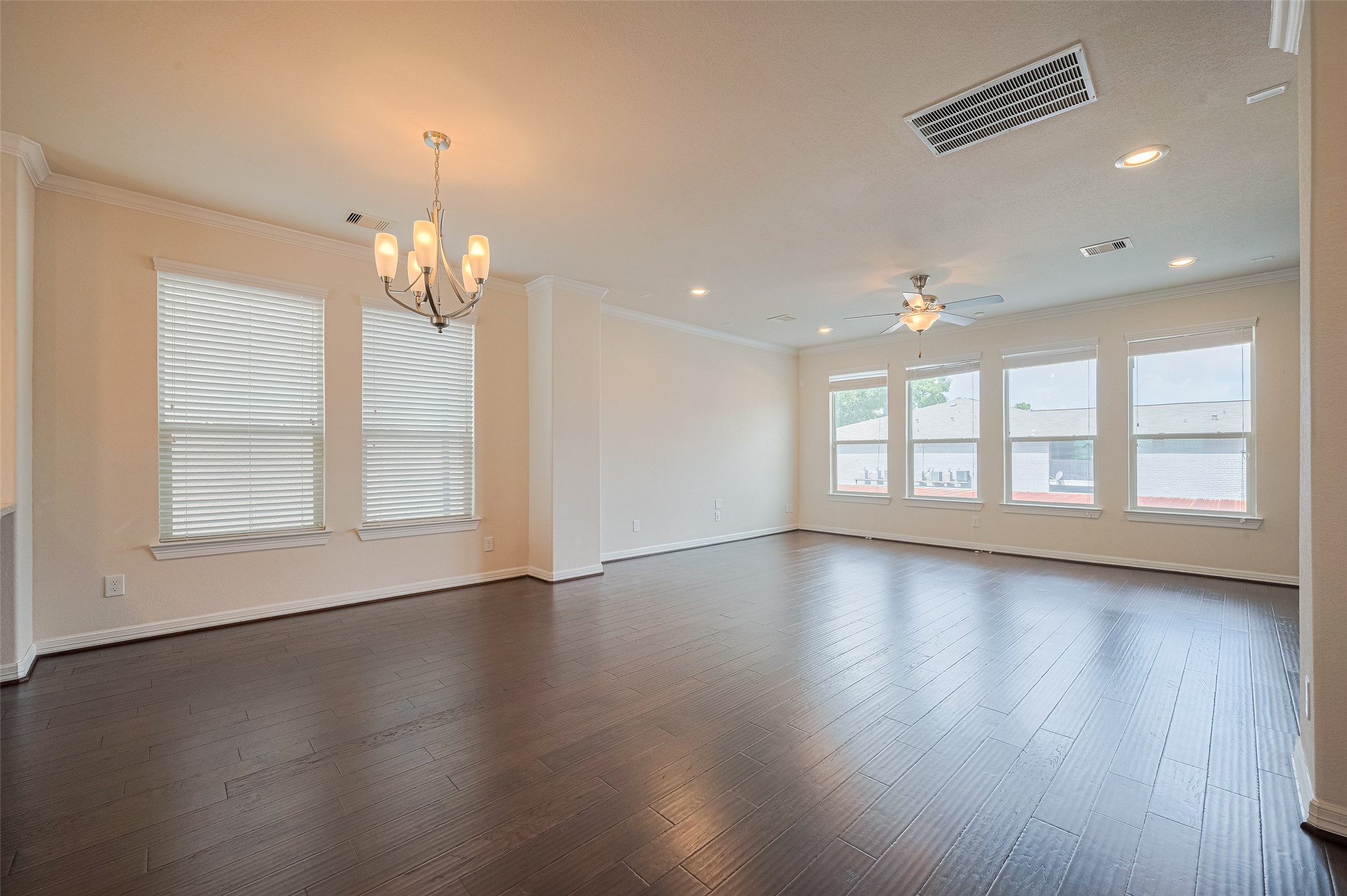 10004 Spring Shadows Park Circle Houston, TX 77080 - Photo 7 of 50 an empty room with wooden floor chandelier and windows
