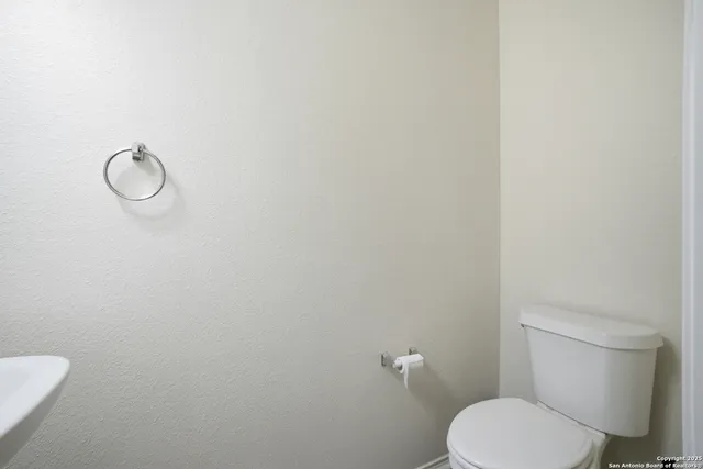 a white toilet sitting next to a white wall