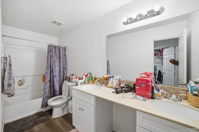 a bathroom with a sink mirror vanity and toilet