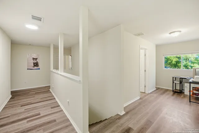 a view of a hallway with wooden floor and a window