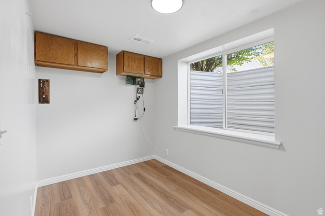 3732 Campbell Road Tooele, UT 84074 - Photo 24 of 69 Room with wood-finish flooring, white walls, and a large window featuring horizontal blinds