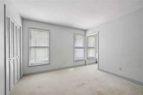 an empty room with windows and closet