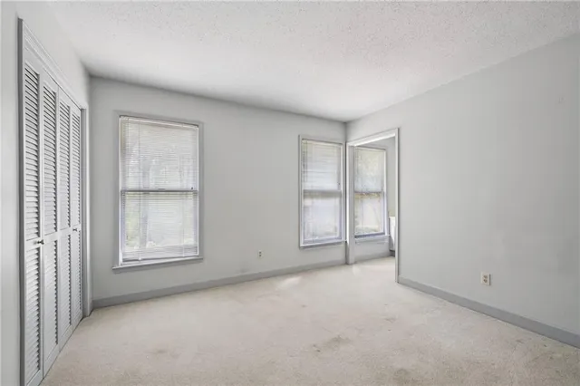 an empty room with windows and closet