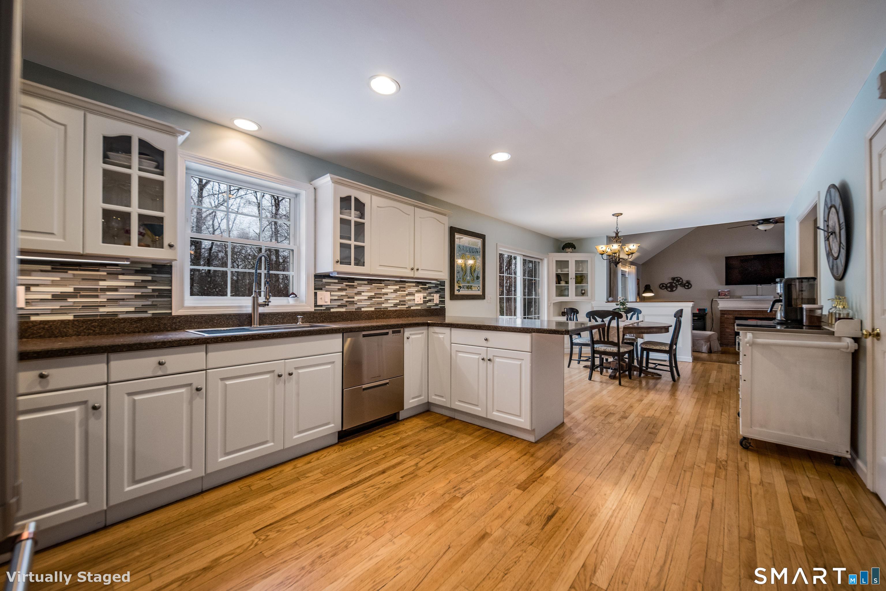 10 Stonewall Lane Clinton, CT 06413 - Photo 5 of 28 a kitchen with stainless steel appliances granite countertop wooden floors and white cabinets