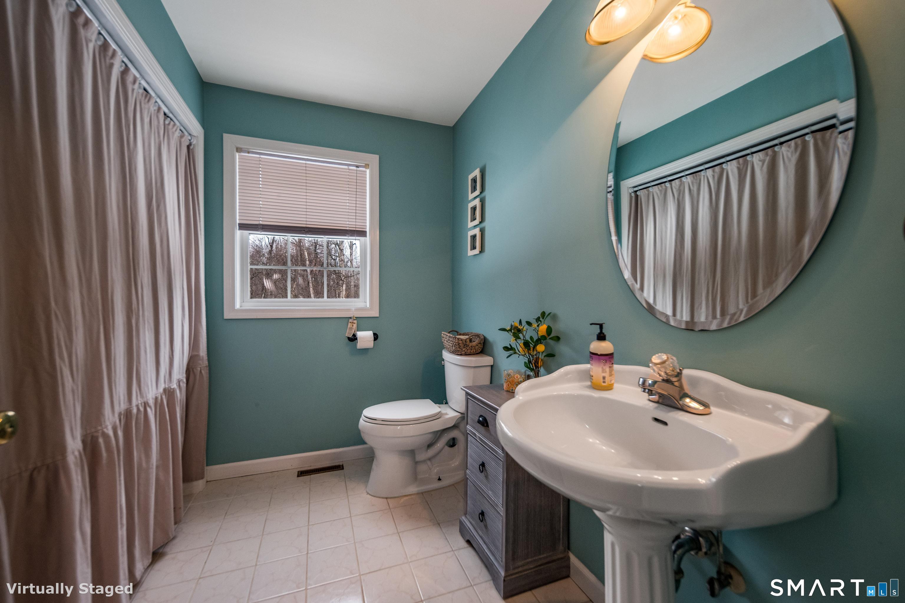 10 Stonewall Lane Clinton, CT 06413 - Photo 9 of 28 a bathroom with a sink a mirror and a toilet