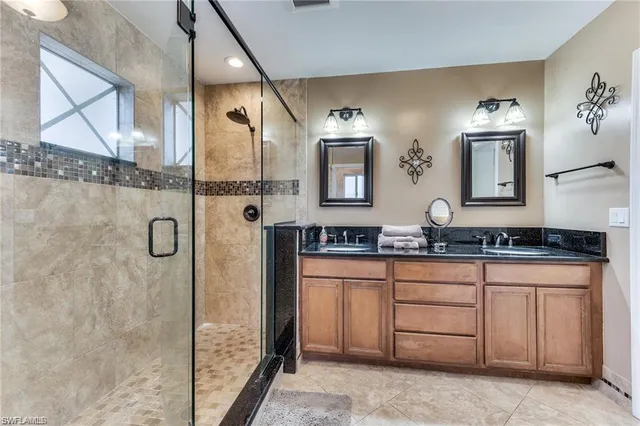 a bathroom with a granite countertop sink a mirror and a shower