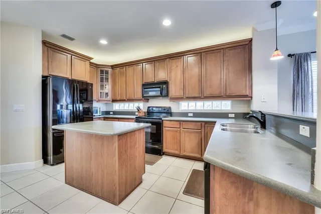 a kitchen with stainless steel appliances granite countertop a sink stove refrigerator and cabinets