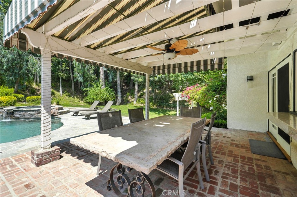 4141 Coldstream Terrace Tarzana, CA 91356 - Photo 32 of 41 a view of a patio with a table chairs and a backyard