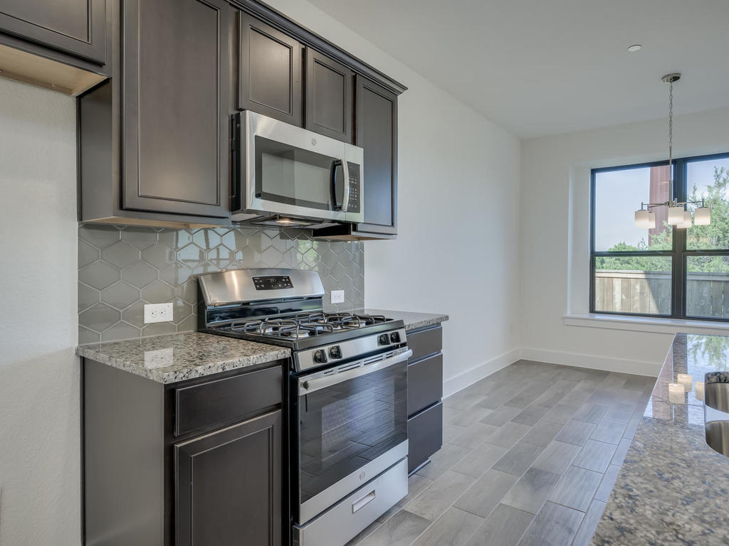 12327 Maypole Bend Austin, TX 78717 - Photo 14 of 30 a kitchen with stainless steel appliances granite countertop a stove microwave and sink