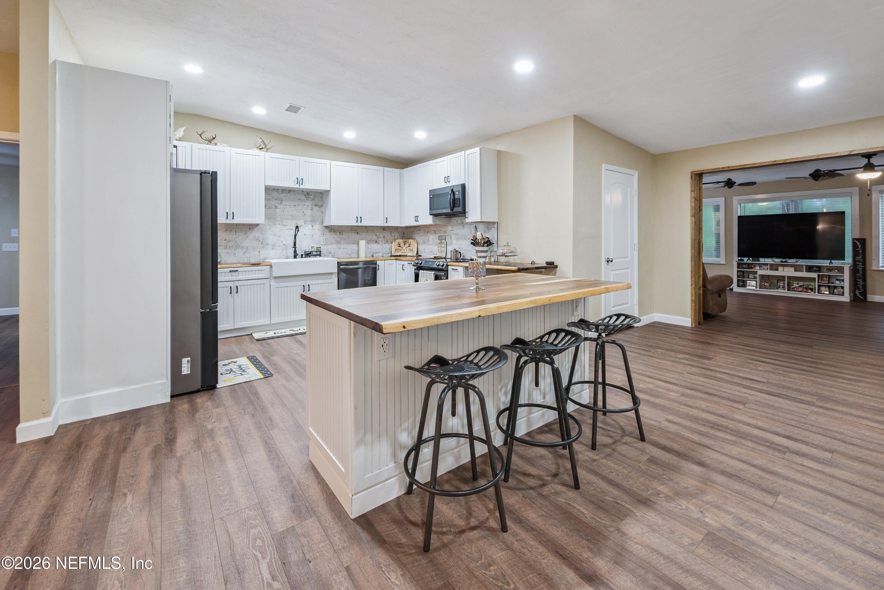 11309 Southwest 167th Circle Brooker, FL 32622 - Photo 15 of 42 a kitchen with stainless steel appliances a dining table chairs and wooden floor