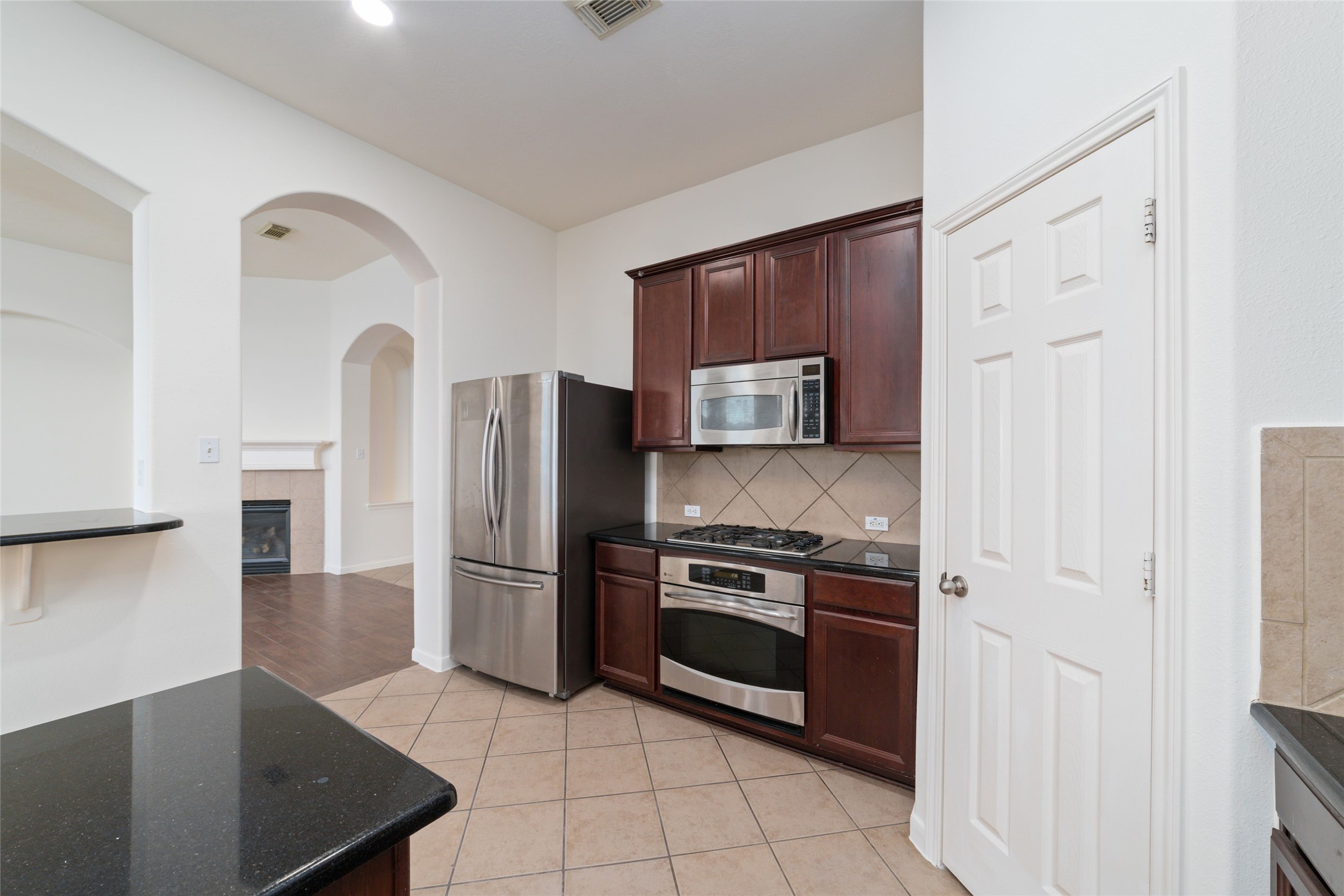 12519 East Nantucket Road Sugar Land, TX 77478 - Photo 12 of 25 a kitchen with stainless steel appliances granite countertop a refrigerator and a stove top oven