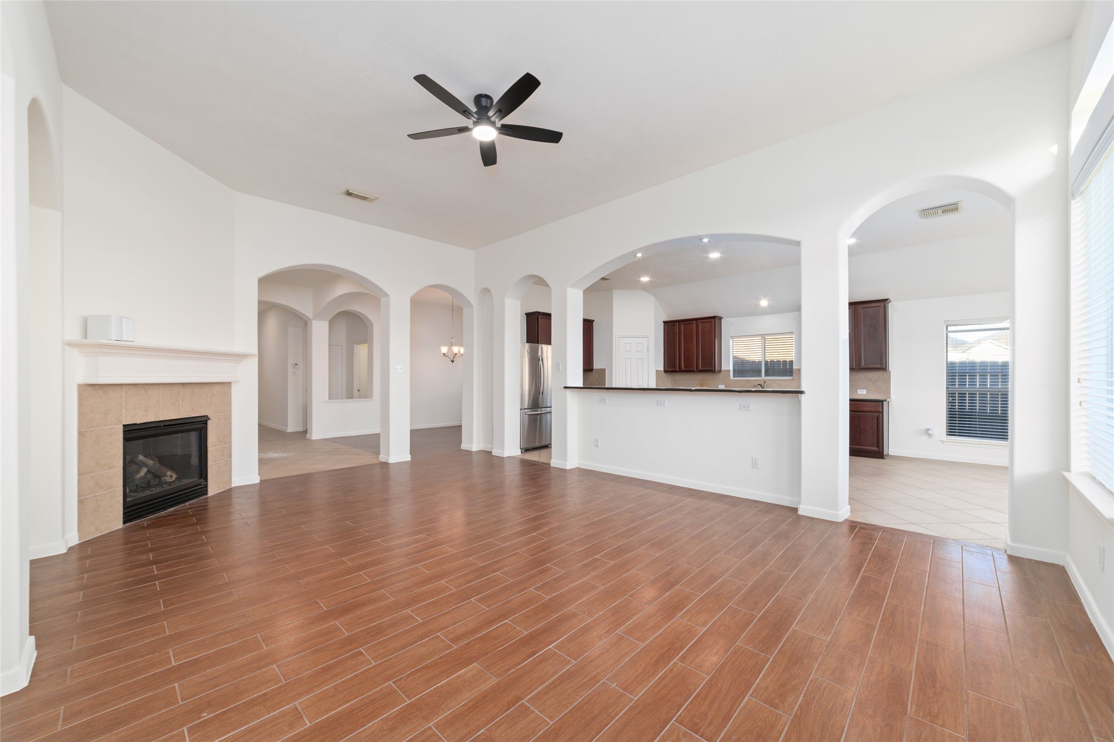 12519 East Nantucket Road Sugar Land, TX 77478 - Photo 5 of 25 an empty room with wooden floor fireplace and windows