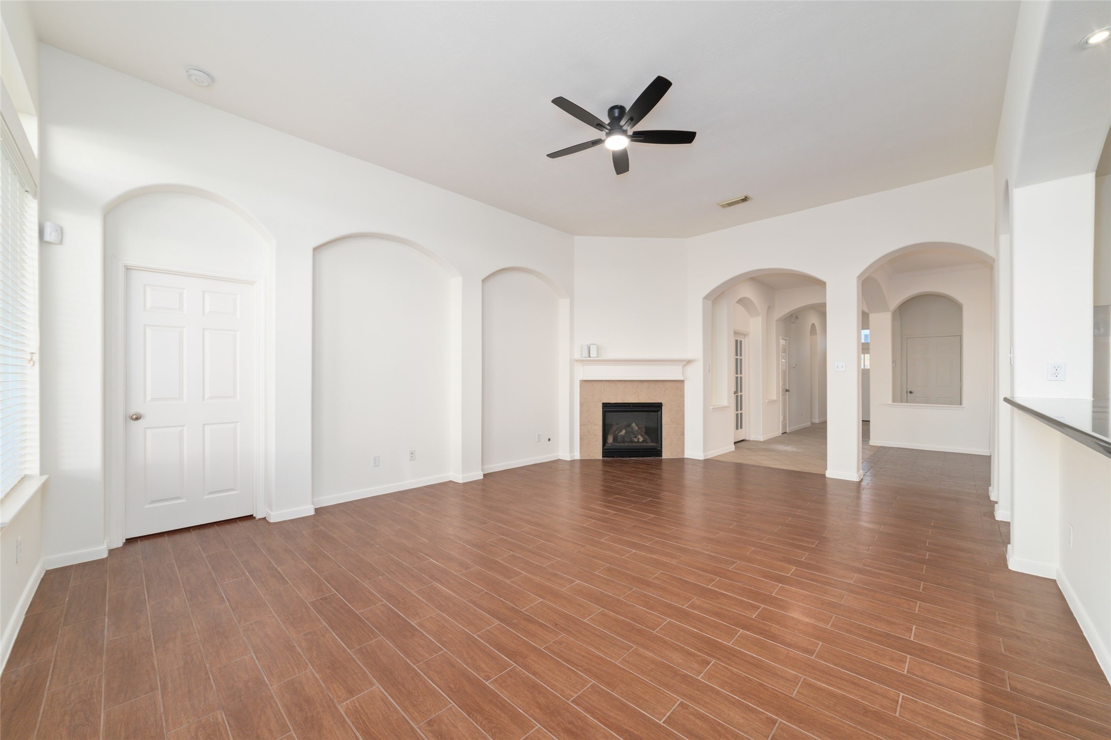 12519 East Nantucket Road Sugar Land, TX 77478 - Photo 6 of 25 a view of empty room with fireplace and wooden floor
