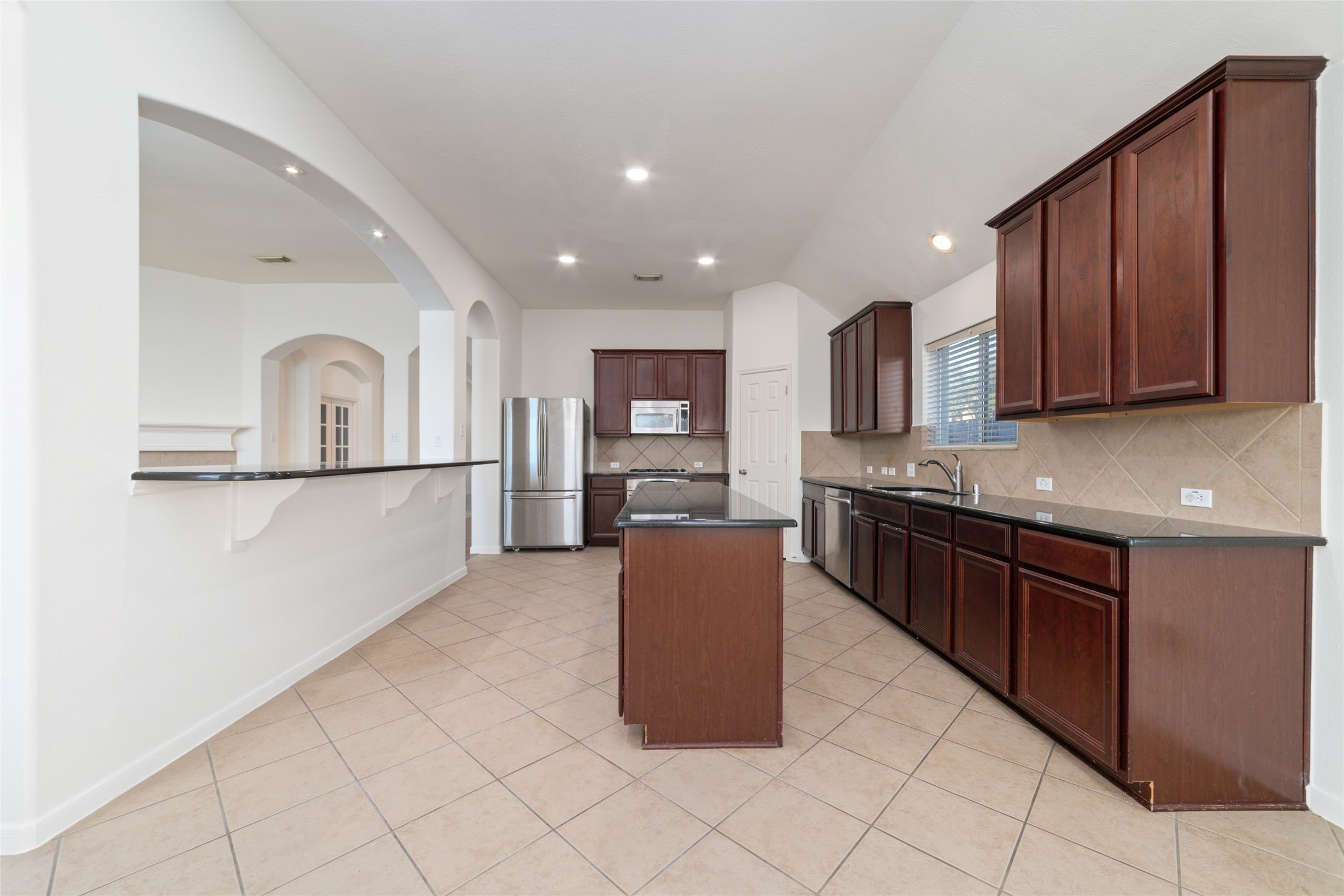 12519 East Nantucket Road Sugar Land, TX 77478 - Photo 9 of 25 a kitchen with stainless steel appliances granite countertop a refrigerator and a sink