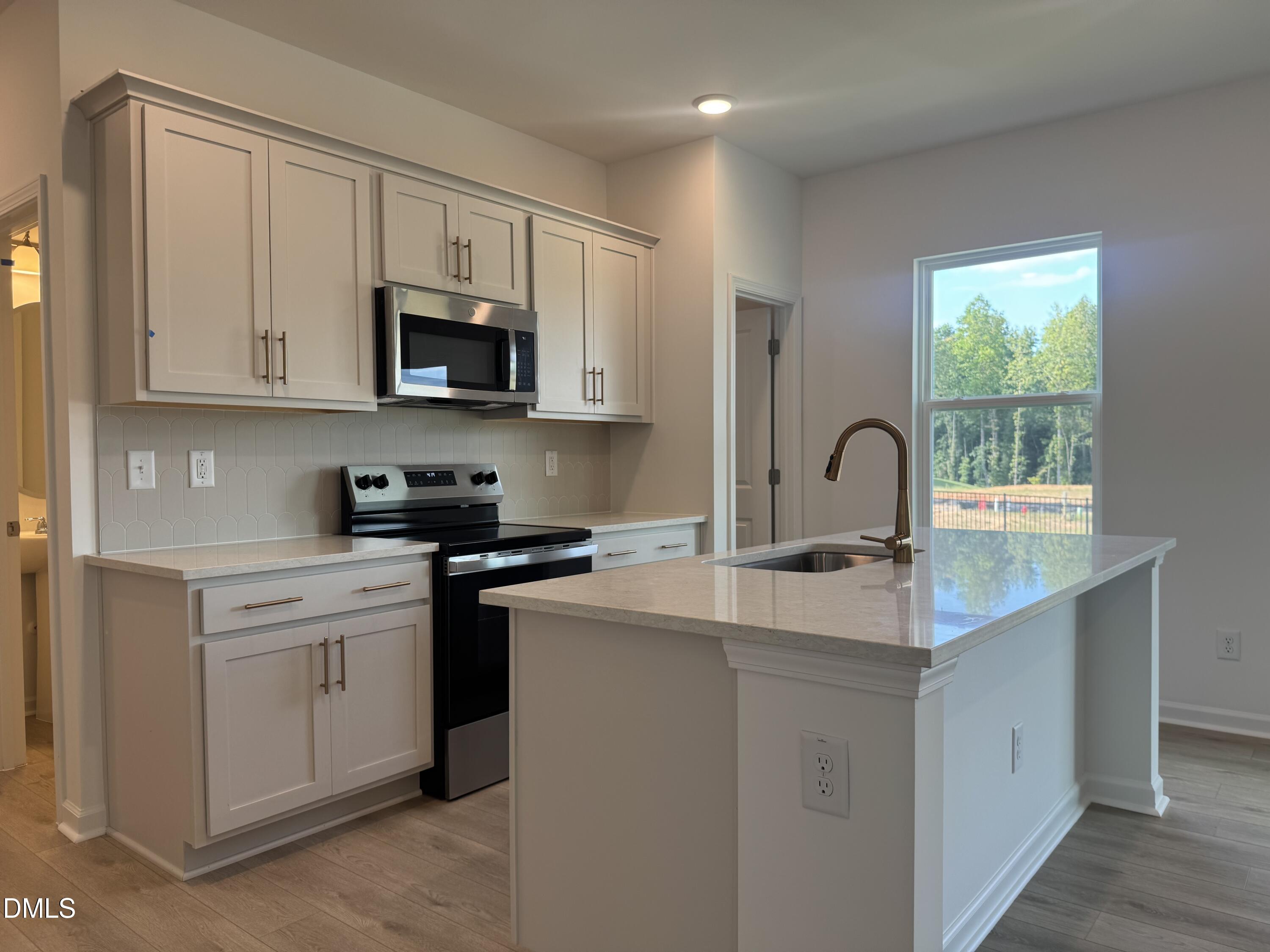 11742 Salers Loop Middlesex, NC 27557 - Photo 11 of 20 a kitchen with stainless steel appliances granite countertop a sink and white cabinets