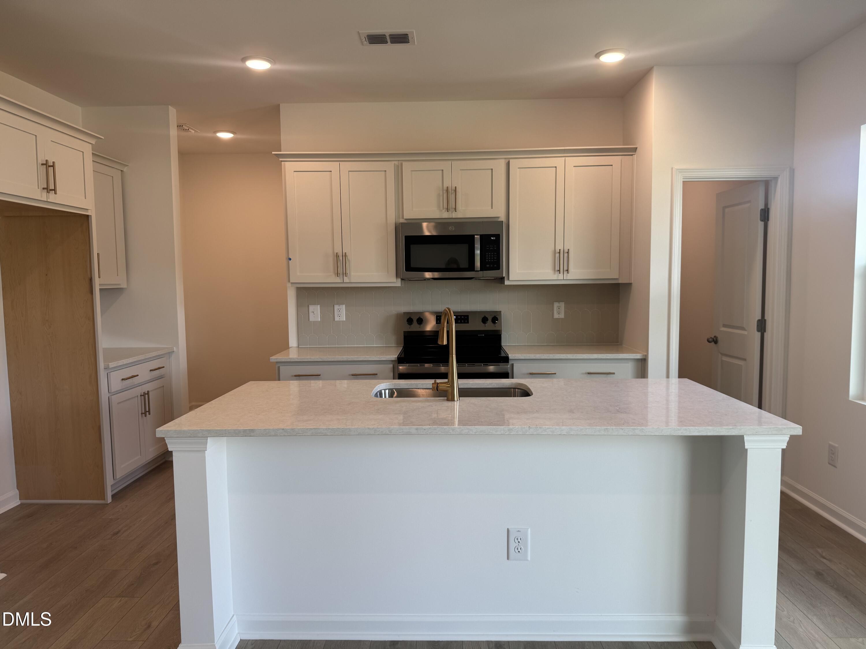 11742 Salers Loop Middlesex, NC 27557 - Photo 2 of 20 a kitchen with kitchen island a sink stainless steel appliances and cabinets