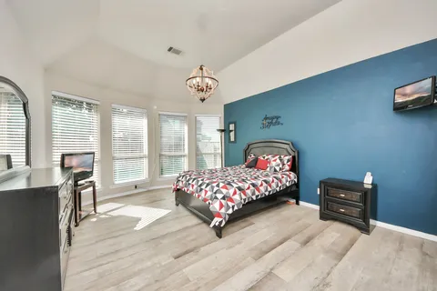 a bedroom with furniture and a large window