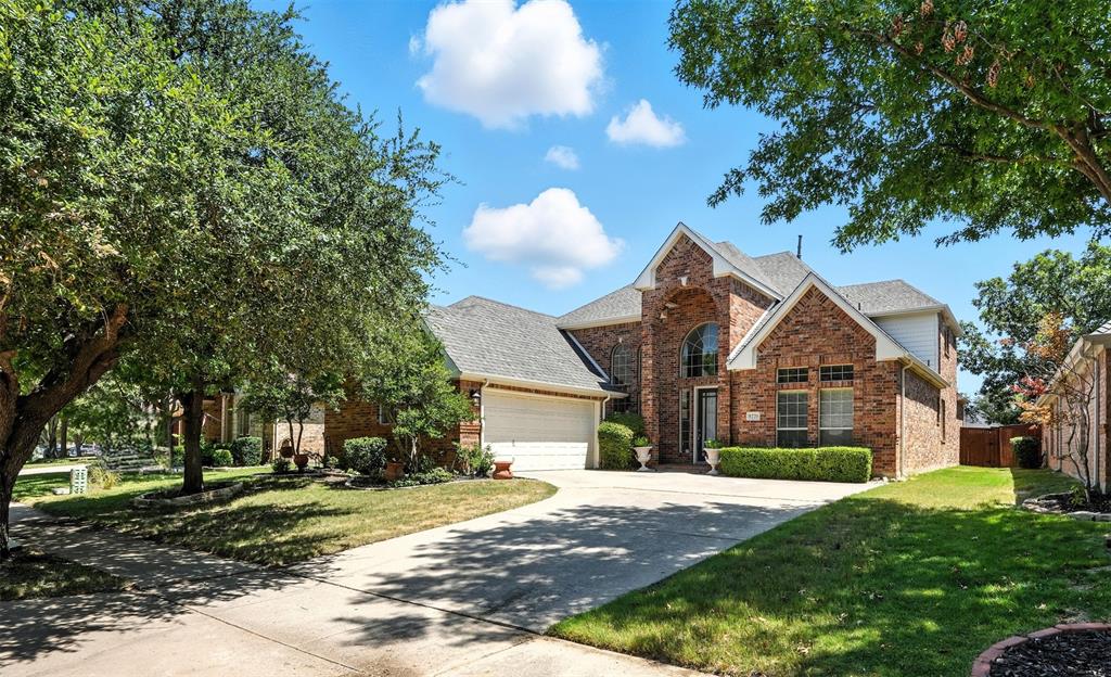 8220 Holliday Road Lantana, TX 76226 - Photo 2 of 40 Brick exterior with a prominent arched entry, gabled rooflines, an attached garage, a concrete driveway, and established perimeter landscaping