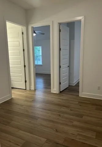 an empty room with wooden floor & closet area