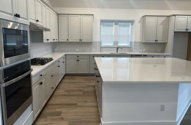a kitchen with granite countertop white cabinets and white appliances